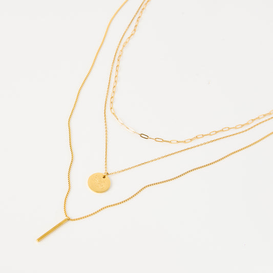 Three gold necklaces on a white background