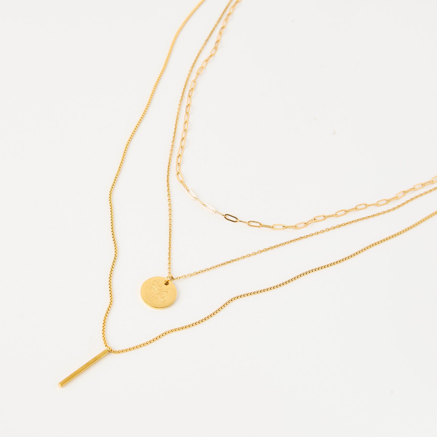 Three gold necklaces on a white background