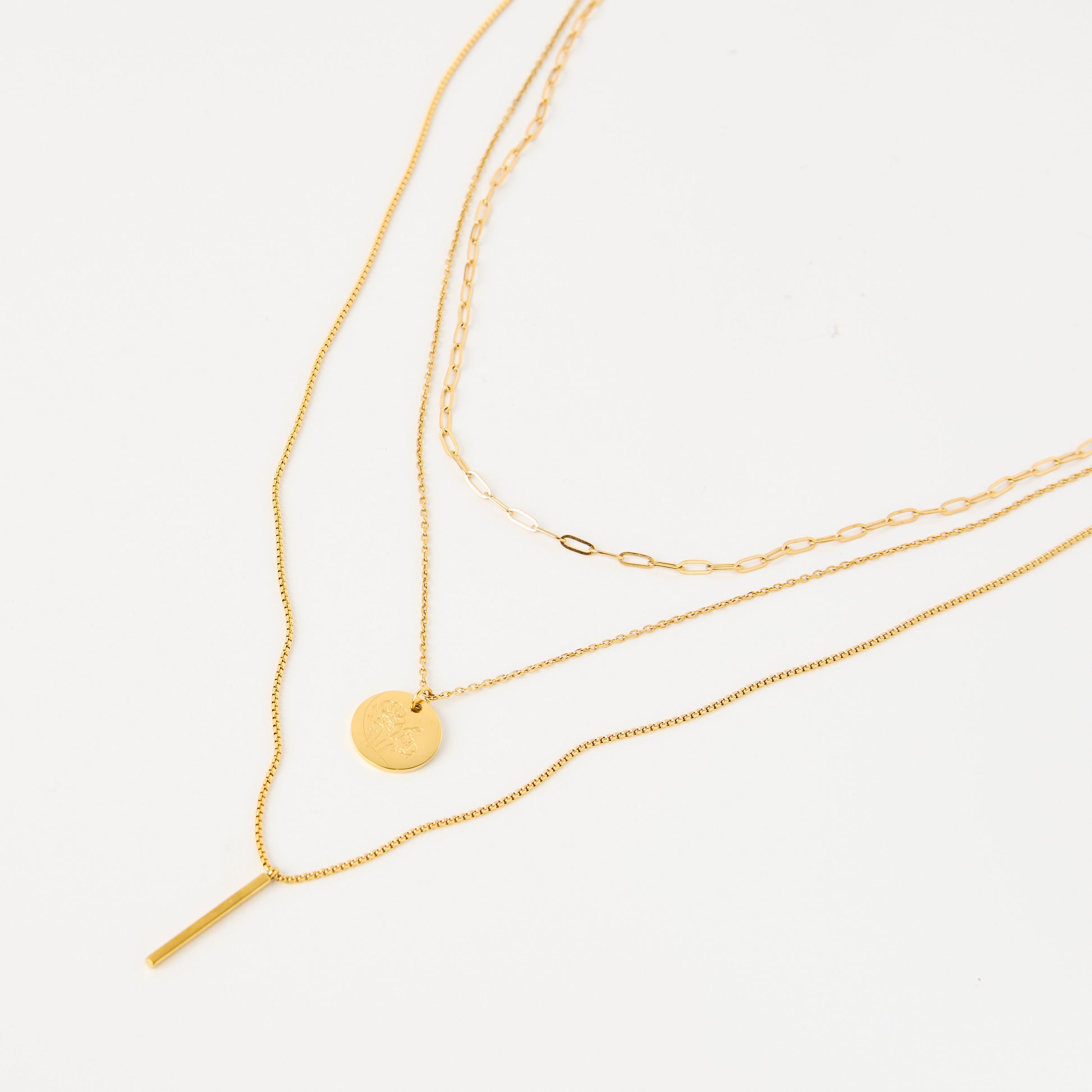 Three gold necklaces on a white background
