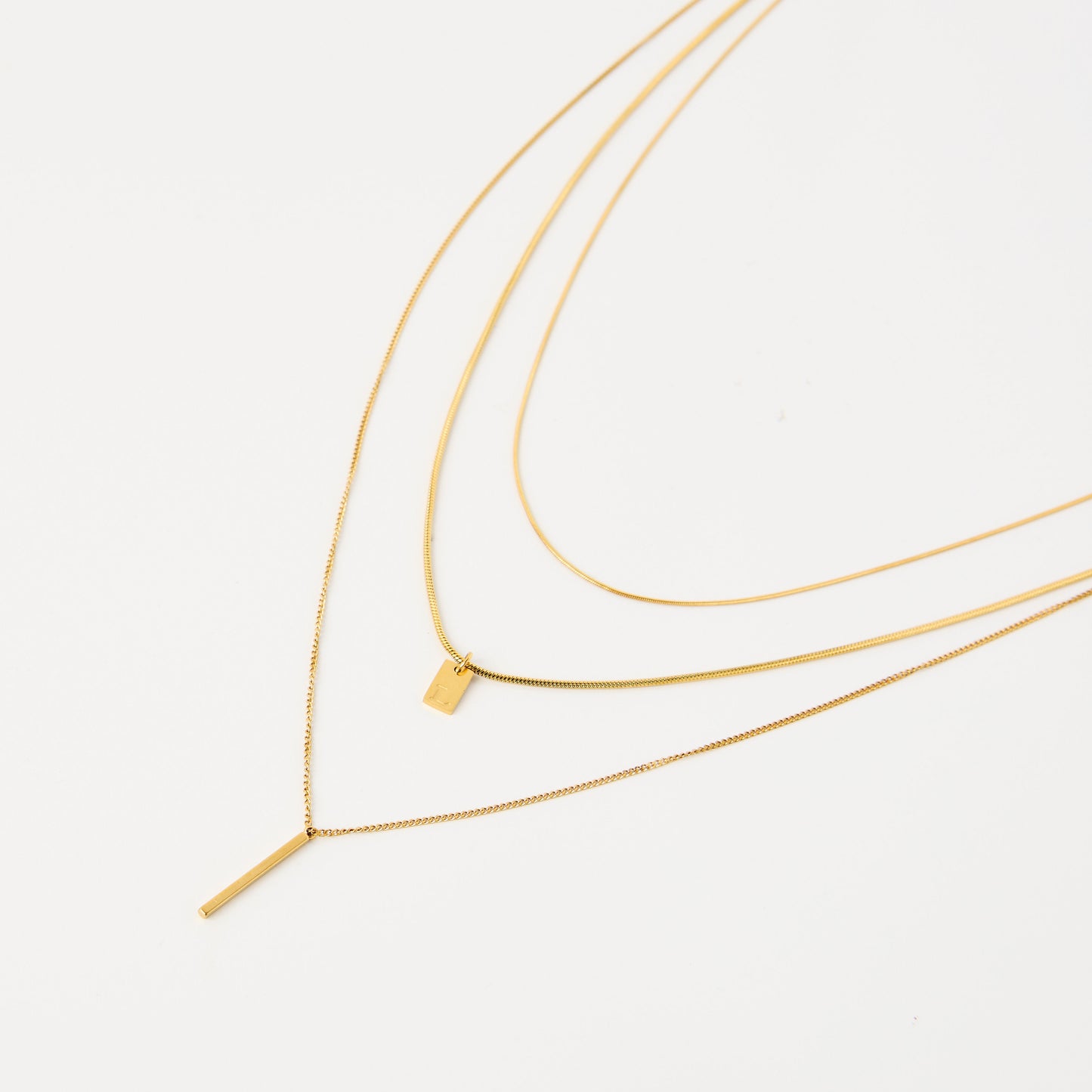 Three gold layered necklace with initial charm.