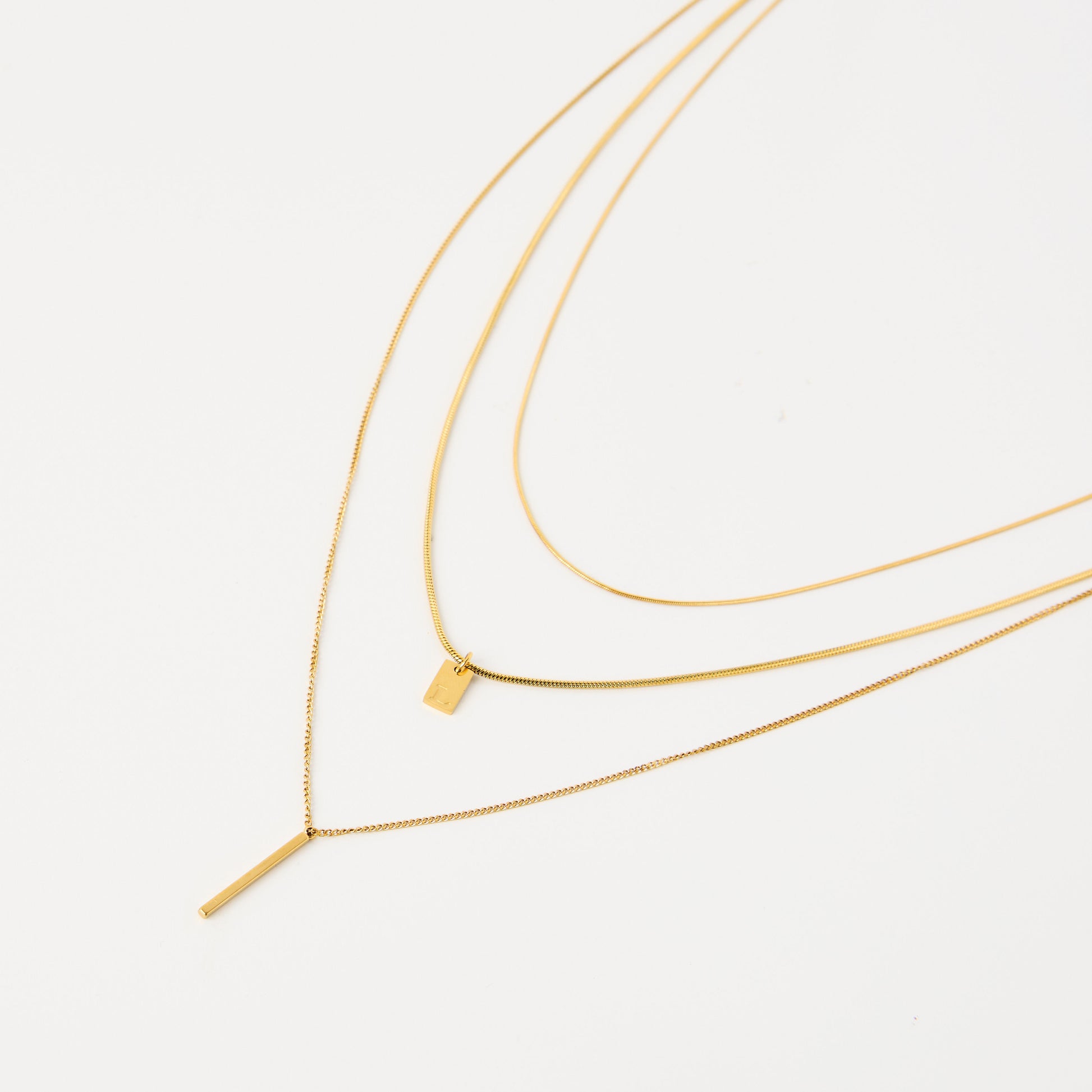 Three gold layered necklace with initial charm.