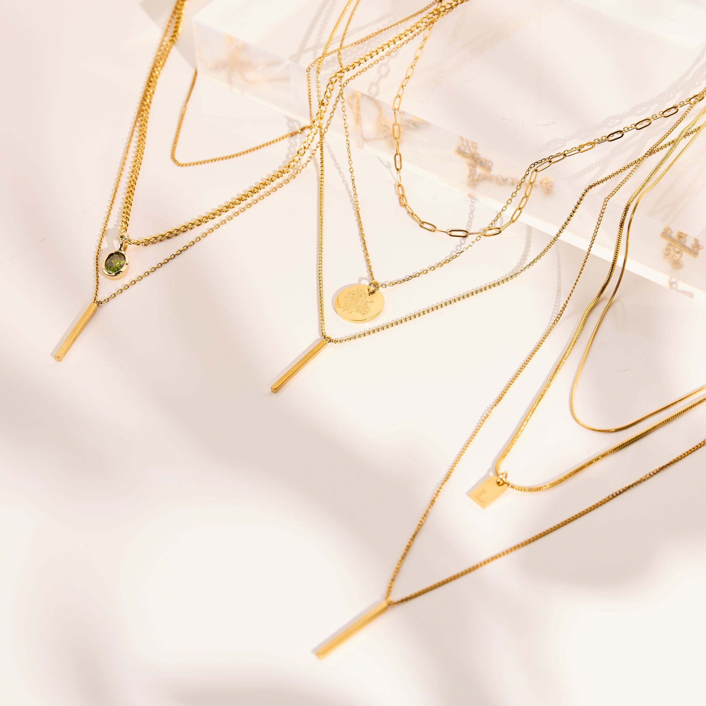 Gold necklaces on a light beige background