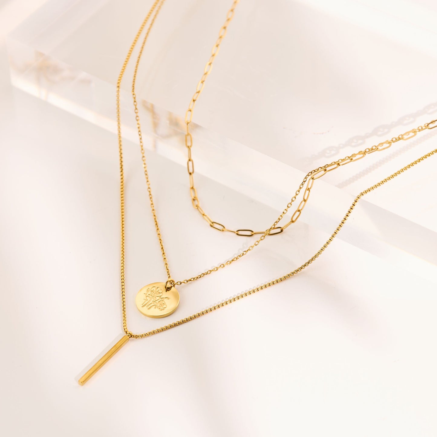 Layered gold necklace with a birth flower round charm.