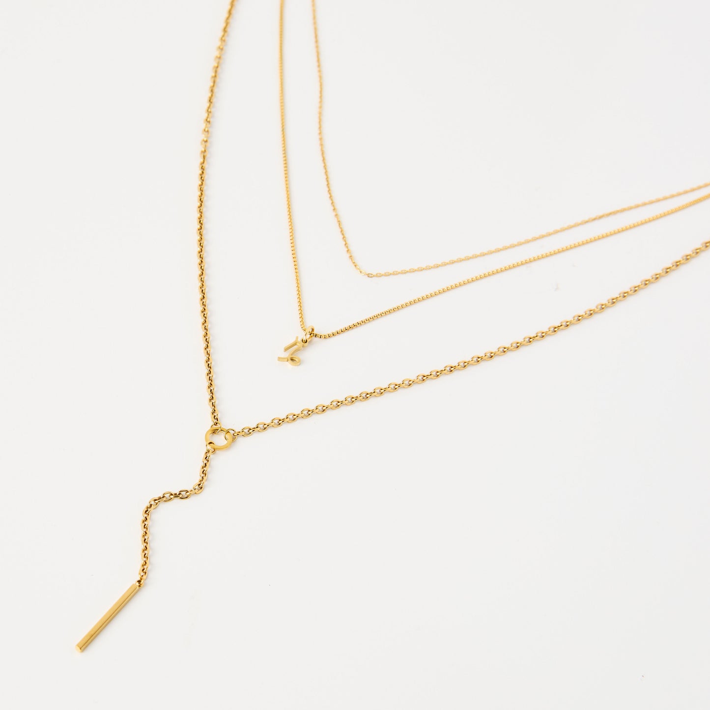Three gold necklaces on a white background