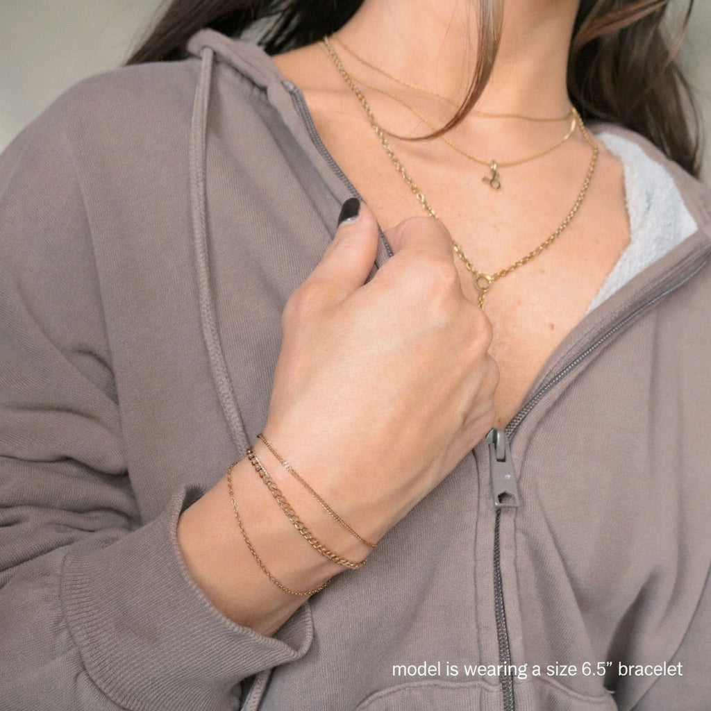 Person wearing a gold layered bracelet